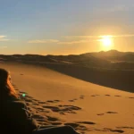 Golden dunes of the Desert of Merzouga at sunset, creating a serene and picturesque landscape.