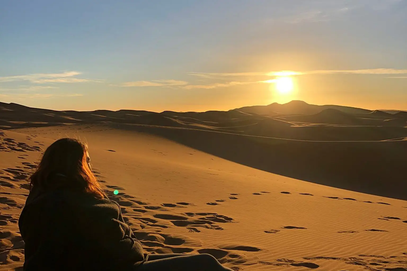 Golden dunes of the Desert of Merzouga at sunset, creating a serene and picturesque landscape.